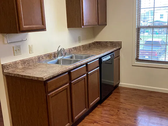 Kitchen with dishwasher and wood cabinetry
