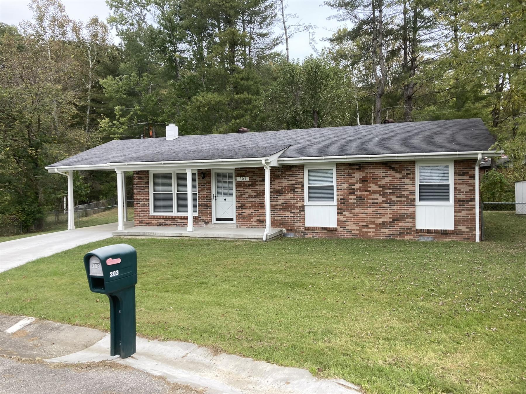Exterior of 203 Scott Court, a brick ranch house with a carport in Irvine, Kentucky